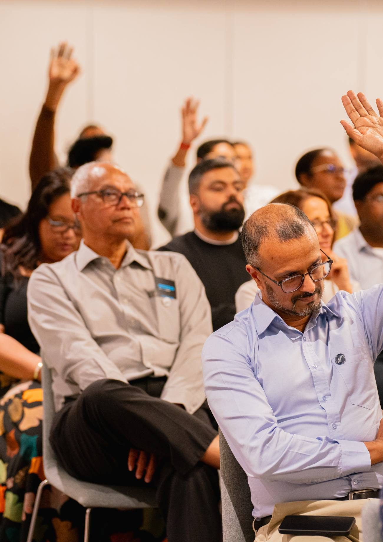 Les mains levées dans la salle, pendant un vote à main levée
