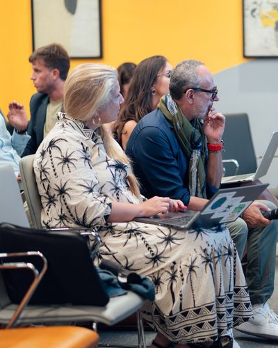 Des participants suivent la démonstration, ordinateurs ouverts